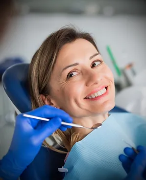 Mujer sonriente en la silla del dentista durante un examen dental